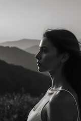 A black and white photo of a woman with mountains in the background