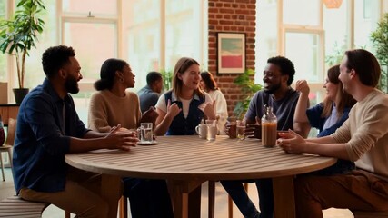 Friendly group enjoying laughter and conversing at a modern cafe table