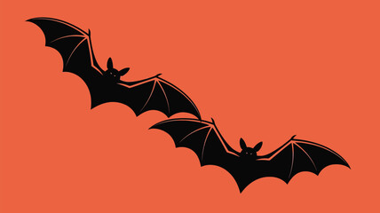 Two black bats flying in orange background for Halloween