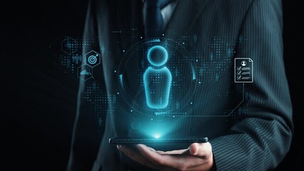 A businessman in a suit holds a smartphone displaying a glowing digital interface. The image represents modern technology, networking, and digital communication advancements. Qubit - Powered by Adobe