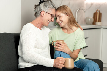 Elderly mother and adult daughter share a joyful moment at home together