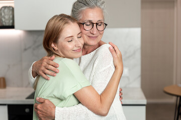 Fototapeta premium Mother and daughter share a warm hug in their cozy apartment on a relaxing weekend
