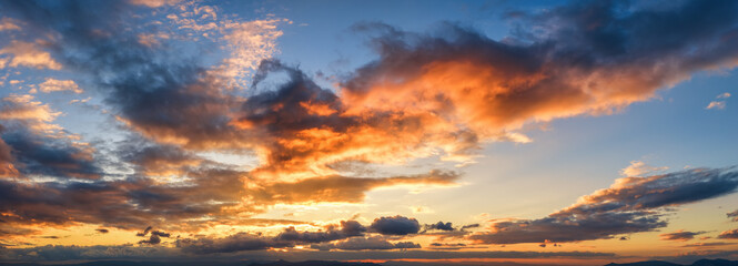 A sunset or sunrise sky panorama with orange and red colors as a background or texture