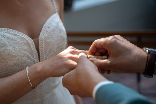 Ring&uuml;bergabe des Brautpaar mit dem Anstecken des Ehering durch den Br&auml;utigam bei der Braut w&auml;hrend der Trauung im Rahmen einer Hochzeit im Standesamt