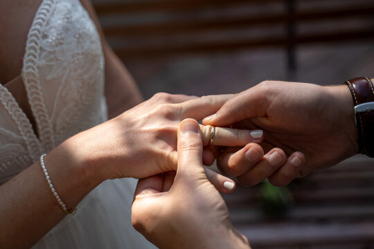Ringtausch des Brautpaar mit dem Anstecken des Ehering durch den Br&auml;utigam bei der Braut w&auml;hrend der Trauung im Rahmen einer Hochzeit im Standesamt