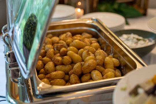 Kleine Kartoffeln in einem Rechauds Warmebeh&auml;lter beim Catering Buffet auf einer Hochzeit
