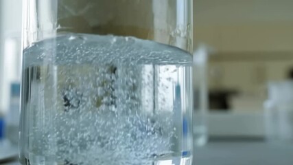 Effervescent tablet dissolving in a glass of water with bubbling action