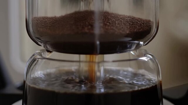 Brewing process: ground coffee falling into dripper with liquid extraction progression