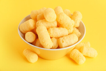 Bowl with sweet corn sticks on yellow background, closeup