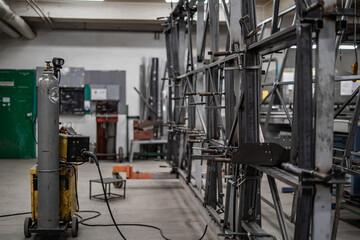 Industrial vehicle manufacturing workshop with metal bus frames and body structures under assembly....