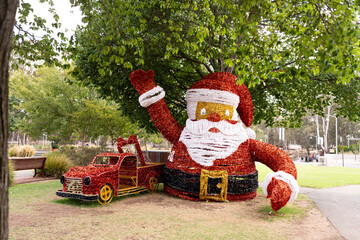 a big santa claus statue decoration in a park