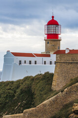 Historic white building with red-roofed lighthouse rises above the rocky landscape of Cape St. Vincent.