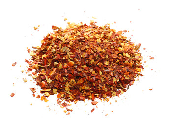 Close up spicy chili red pepper flakes, chopped, milled dry paprika pile isolated on white