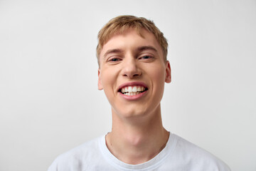 Smiling man in a white t shirt with a bright grin, close up head and shoulders, conveying happiness, warmth and friendly vibe for lifestyle, fashion and social media use