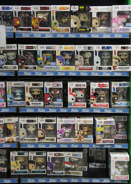 Shelves filled with Funko Pop collectible figures in original packaging at a retail store. Various pop culture characters from movies and games on display for sale.