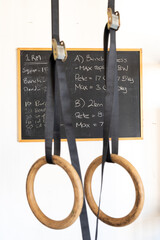 two fitness rings hanging with a chalkboard in the background tracking personal best fitness statistics