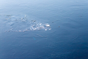 Frozen blue water surface reflecting light