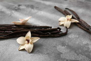 Vanilla sticks and flowers on grunge background