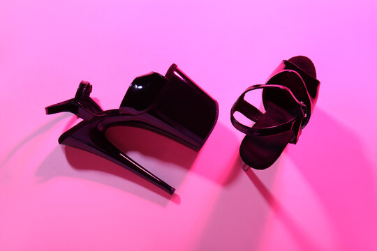 Stylish black high heels for pole dance on pink background
