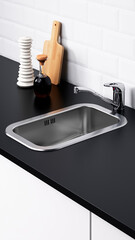 Kitchen sink area with utensils and a bottle on a countertop in a modern design setting.