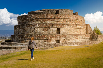 Tourist woman walking towards ancient Ehecatl Quetzalcoatl temple in Calixtlahuaca, Mexico