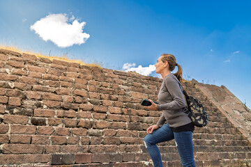 Tourist woman climbing ancient Tlaloc temple steps in Calixtlahuaca, Mexico