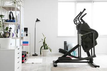 Interior of stylish gym with modern exercising bike and sports equipment