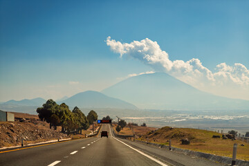 Car driving on scenic highway towards active Xocotepetl volcano in Mexico