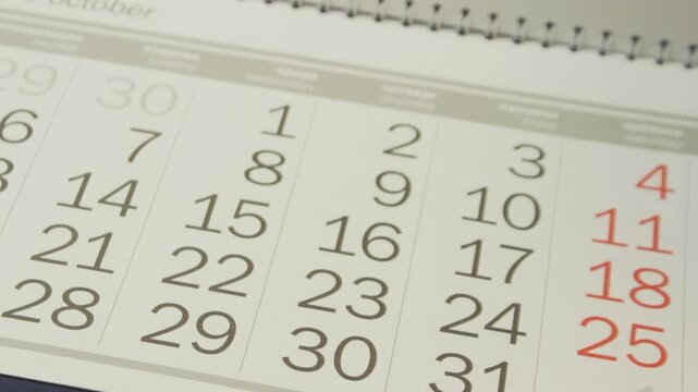 Paper calendar pages turning rapidly one by one in close-up, illustrating fast passage of time and approaching deadlines or events