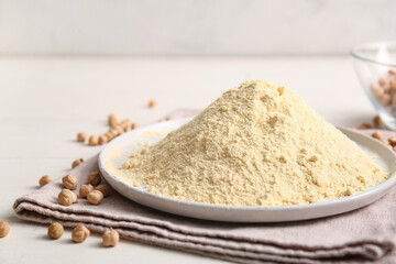 Plate with chickpea flour and beans on white wooden table