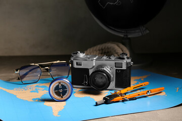 Composition with modern compass, photo camera and divider on grey grunge background