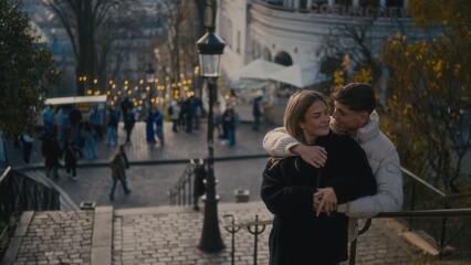 A romantic couple embraces in Montmartre Paris France with a cityscape view in the background. This image is perfect for travel tourism and lifestyle content showcasing love and affection in an urban 