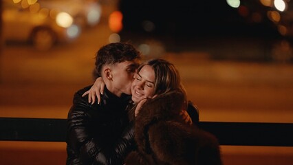 A romantic couple embraces on a bench in Paris at night with bokeh lights creating a warm and intimate atmosphere The image conveys love affection and the joy of being together in the beautiful city o