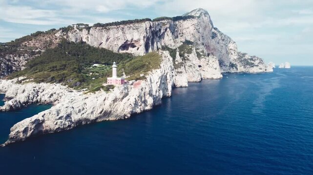 Lighthouse and Beach of Capri in summer season. View from a moving drone