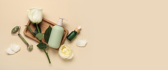 Beautiful white roses, bottles of cosmetic products and jade massage roller on beige background with space for text