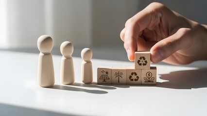 Hand placing wooden block with recycling symbols near wooden figures on white surface
