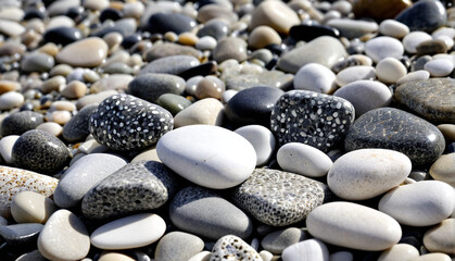 A uniform pattern of various pebbles in shades of white, grey, and black creates a serene beach scene