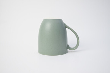 Modern green ceramic mug with a matte finish and speckled texture, isolated on a clean white background