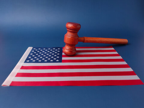 Wooden gavel resting on a folded United States flag