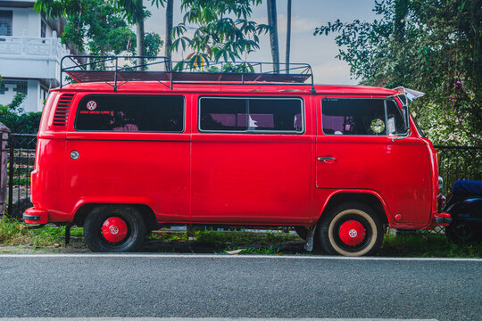 Side View of Bright Red Vintage Volkswagen T2 Kombi Bus with Roof Rack
