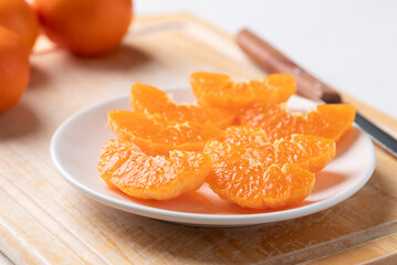 Sliced Mandarin orange fruit on plate ready to eating