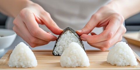 Hands pressing warm rice into triangular onigiri mold in kitchen  
