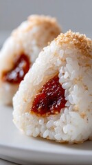 Close-up of onigiri rice balls with umeboshi filling on plate  