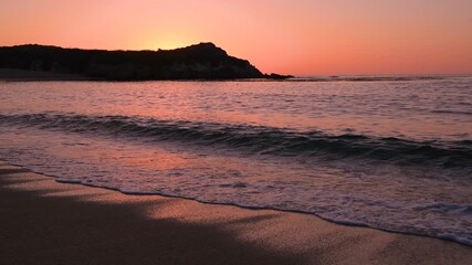 Sunset Monastery Beach - A wide-angle sunset view of strong waves crashing on sandy Monastery Beach on a colorful and calm Summer evening. Carmel, California, USA.