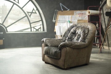 Blurred abstract background with an empty vintage armchair in a dark vintage room with a large semicircular window with a clock facing the city