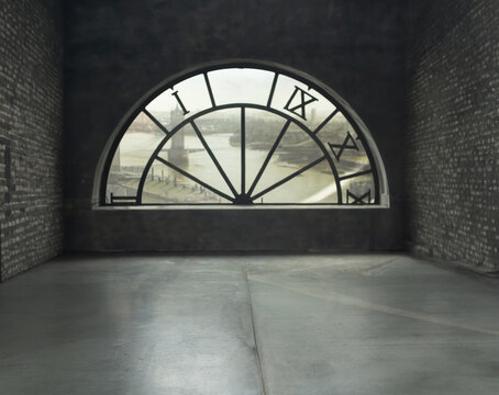 A blurry abstract background with an empty vintage room, a large semicircular window with a clock facing the city