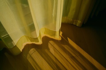 Warm sunlight filters through sheer curtains onto wooden floor