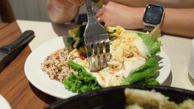 Woman Eating Healthy Quinoa Salad at Restaurant Table
