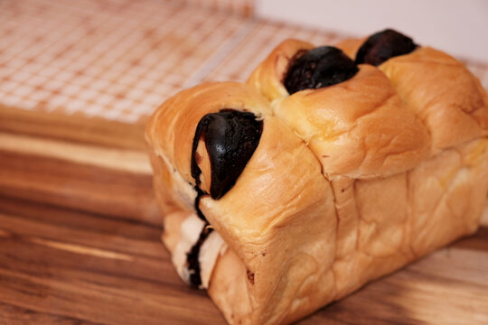 Torn bread or roti sobek in indonesian on wooden board, usually filled with chocolate, fruit jam, or cheese. eaten by tearing into pieces according to the serving. 