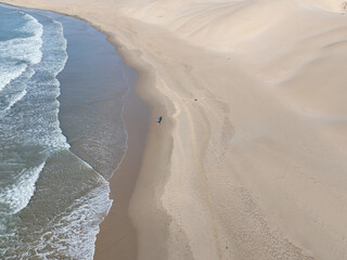 aerial view of man running along the coast